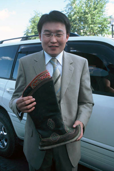 Special deilvery of hand-made boots by young man in western style suit 